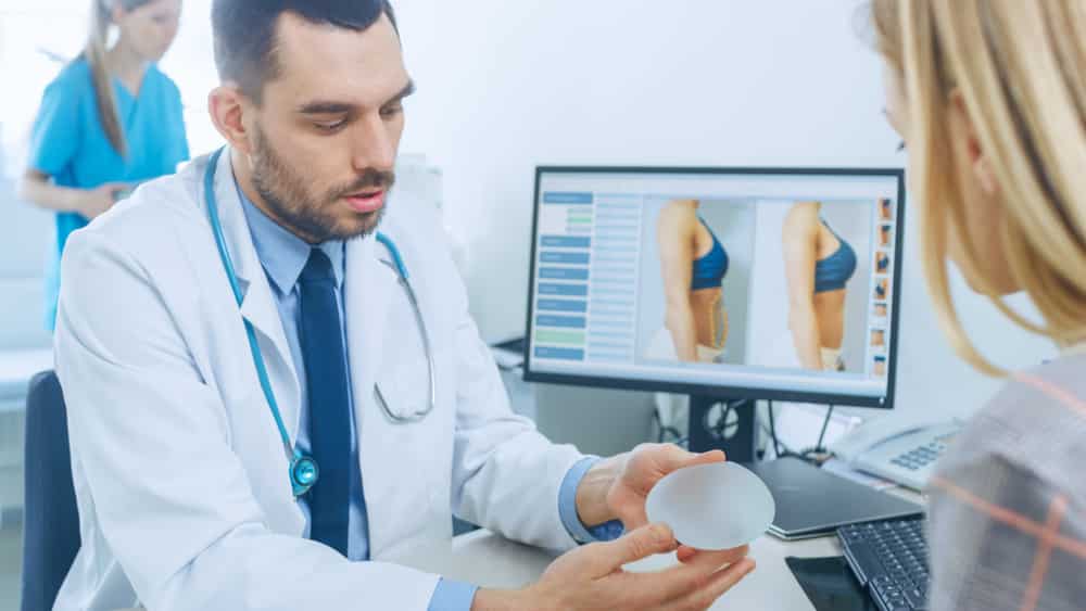 A plastic surgeon helping a woman choose the type of implants for her breast augmentation