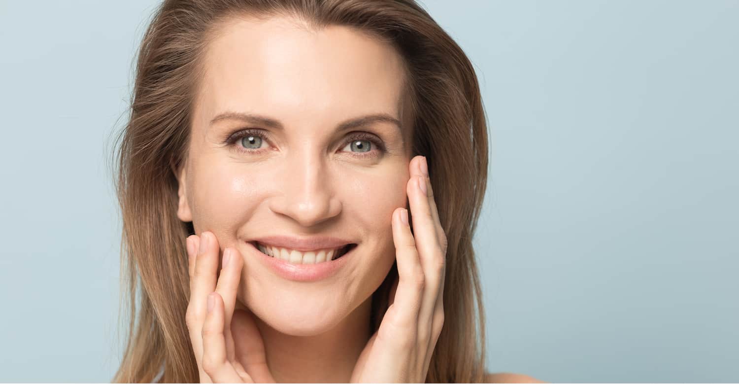 A woman smiling after eyebrow lift surgery