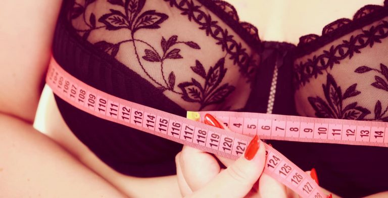 A woman measuring her chest in preparation for breast reduction recovery