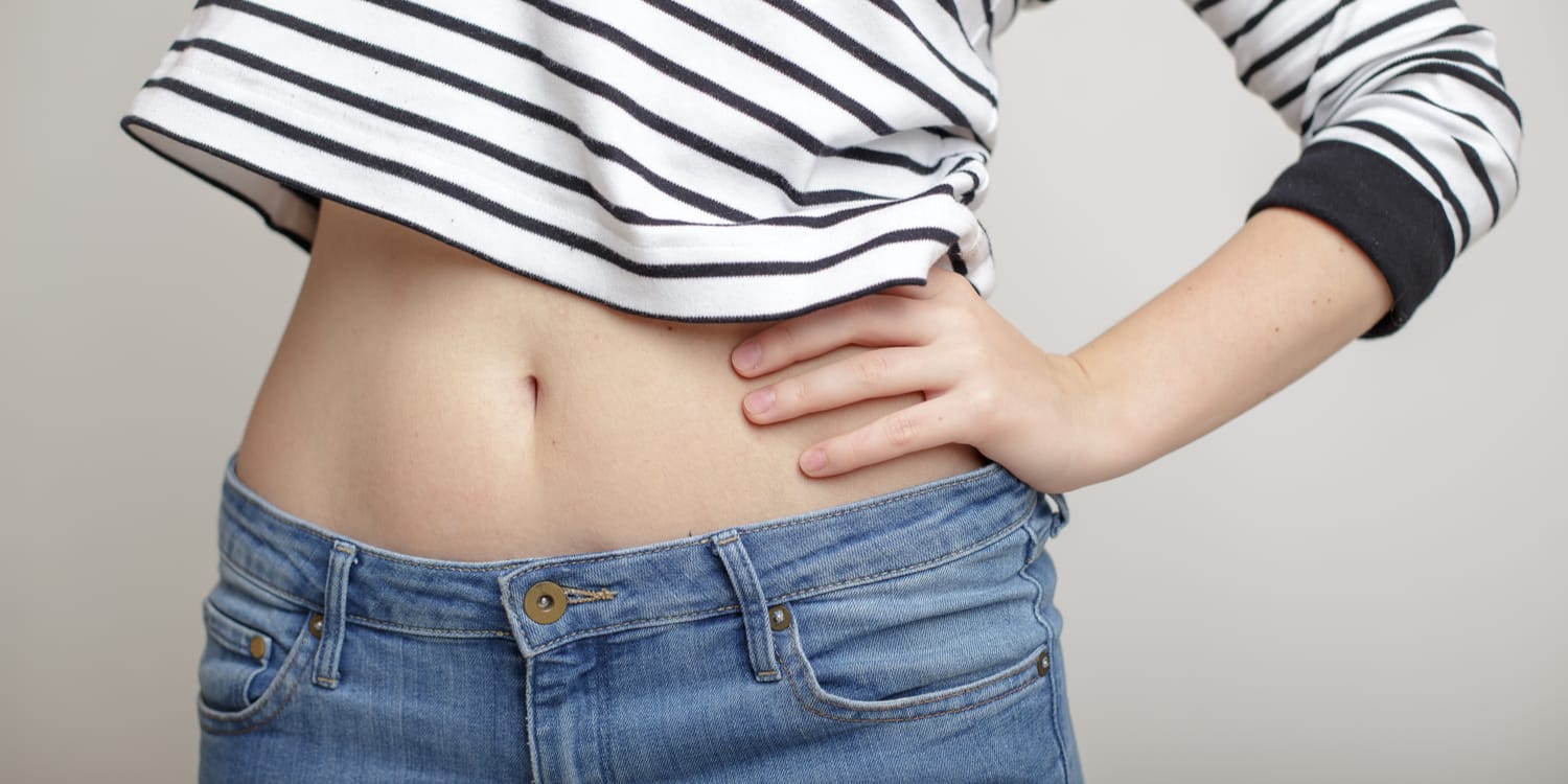 A woman in striped shirt with a flat stomach after mommy makeover plastic surgery