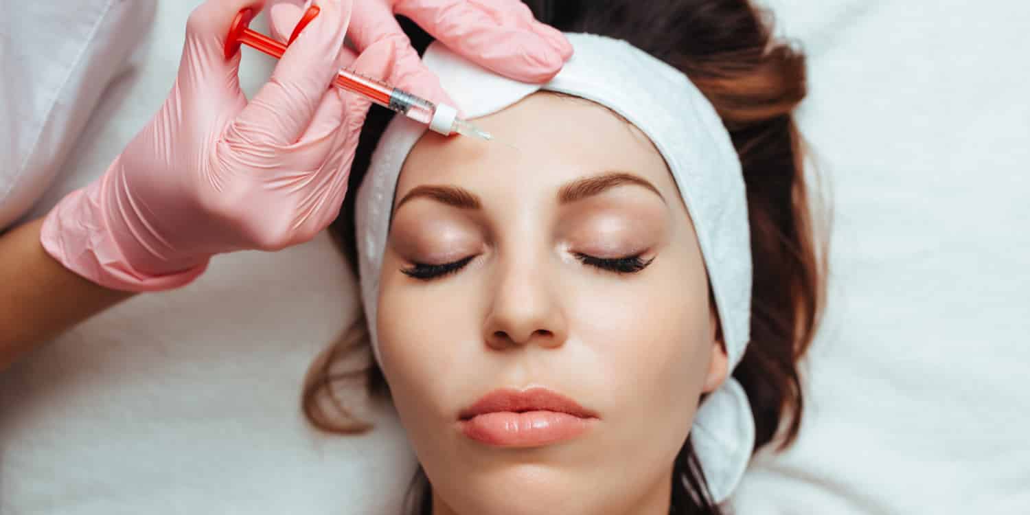 A young woman getting preventative botulinum toxin (Dysport) injections