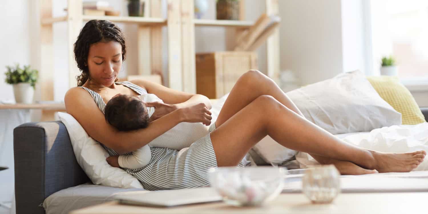 A woman breastfeeding with breast implants