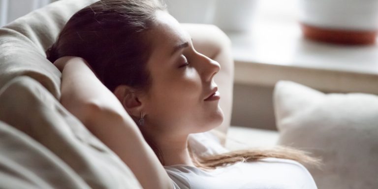 A woman relaxing as part of pain management after plastic surgery